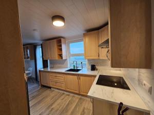 GardurVOT Vacation Homes-Akurhús的厨房配有木制橱柜和台面