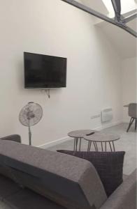 罗瑟勒姆Modern Loft Apartment的客厅配有沙发、桌子和平面电视。