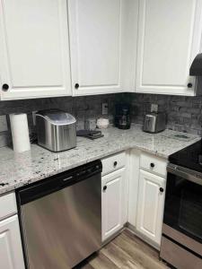 格林维尔Beautiful Home In Greenville的厨房配有白色橱柜和不锈钢洗碗机。