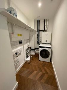 泰晤士河畔金斯顿Kingston Star的洗衣房配有洗衣机和烘干机