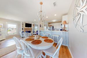 托普赛尔海滩Compass Rose的厨房以及带白色桌椅的用餐室。
