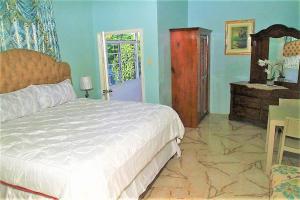 尼格瑞尔Dela de-Rose Guest House Negril Jamaica的卧室配有床、桌子和门