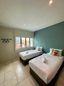 乔治市Swing & Pillows @ Malabar的客房设有两张床和窗户。