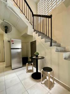 乔治市Swing & Pillows @ Malabar的厨房配有桌子、冰箱和楼梯。