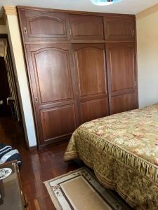 科恰班巴HABITACIONES PRIVADAS NOVILLO的卧室设有一张大床旁的大木墙
