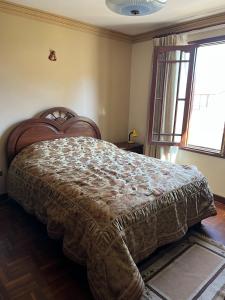 科恰班巴HABITACIONES PRIVADAS NOVILLO的一间带一张大床的卧室,位于带窗户的房间内