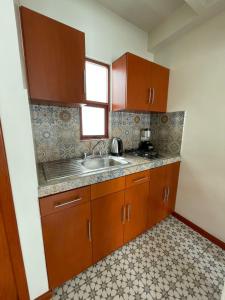 瓦哈卡市Casa Sol的一个带木制橱柜和水槽的厨房