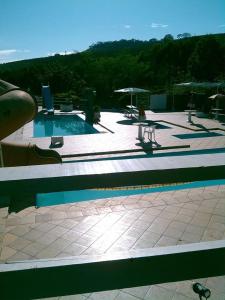塞拉内格拉西提欧博姆芬旅馆的庭院内一个带桌子和遮阳伞的游泳池