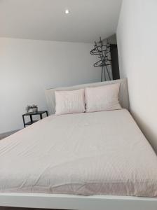 法鲁Divine Room的白色的床、白色床单和枕头
