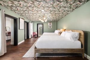 新士麦那海滩Victoria 1883的一间卧室设有两张床,天花板上覆盖着树叶