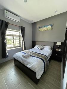 Bến CátAnna Hotel Binh Duong的一间卧室设有一张床和一个窗口