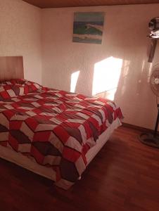 拉帕洛马Tákate DoS的一间卧室配有一张带红色和黑色棉被的床