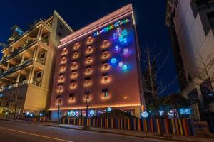 金海市Jangyu Almond Kids Hotel的一间酒店,旁边有一个灯光标志