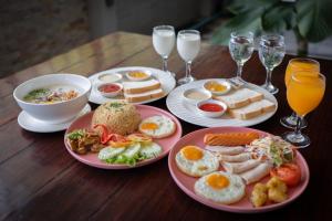 莱卡邦Gate43 Airport Hotel的一张木桌,上面放有早餐食品和饮料盘