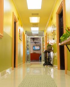 ComayagüelaHotel Reynieri的一间医院的空走廊,有黄色的墙壁和黄色的天花板