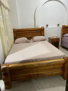 TumbaPara buenos gustos, buen confort的一张带白色床单和枕头的木床