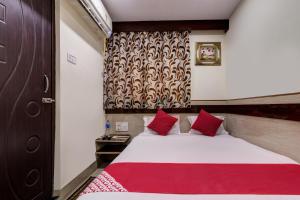 贾姆谢德布尔OYO Hotel Satguru的一间卧室配有一张带红色枕头的大床