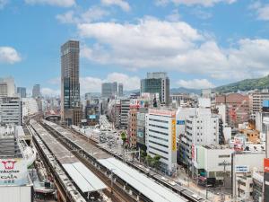 神户Sotetsu Fresa Inn Kobe Sannomiya的享有火车轨道和建筑的城市美景