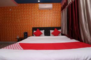 GauripurOYO Hotel Jagannath International Near Kolkata Airport的一间卧室配有一张带红色枕头的大床