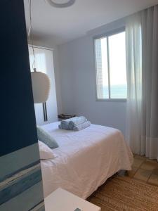 维拉维尔哈Apartamento Renovado na beira da Praia的白色的卧室设有床和窗户