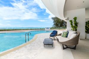 纳仲天Ocean Marina Resort Pattaya Jomtien的一个带游泳池、沙发和椅子的庭院