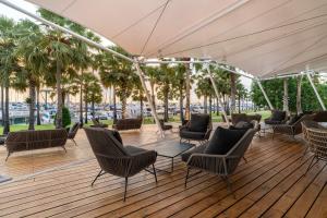 纳仲天Ocean Marina Resort Pattaya Jomtien的木制甲板上配有桌椅的庭院
