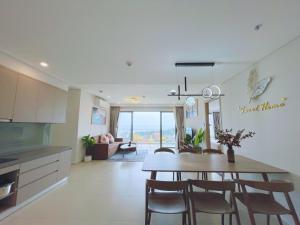 头顿Sóng Homestay - Căn Hộ The Sóng Vũng Tàu Nghỉ Dưỡng Biển Cao Cấp 5 Sao - The Song Vung Tau Condotel 5 Star Beach View Apartment的厨房以及带桌椅的用餐室。