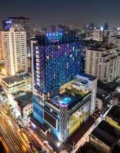 曼谷VELA Dhi GLOW Pratunam的一座晚上在城市里灯火通明的建筑