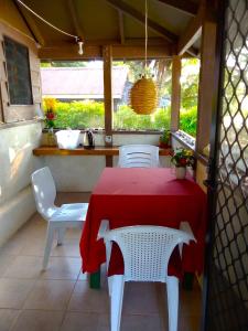 维拉港Vatupau Beachfront Bungalows的露台上配有红色桌子和白色椅子
