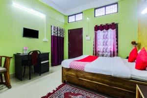 BhutiāgāonOYO Alohi Ghar的一间卧室配有一张床、一张书桌和一台电视