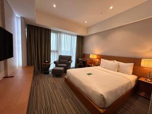 仁川市Hotel Tour Incheon Airport Hotel & Suites的配有一张床和一把椅子的酒店客房