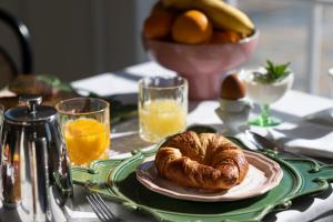 罗兰低地Le Mas Barossa的一张桌子,上面放着一盘面包和橙汁
