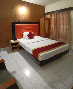 达卡Hotel Skylink的一间卧室配有一张大床和木制床头板