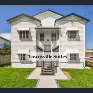 汤斯维尔Townsville Suites的白色的房子,上面有单词stownsville套房