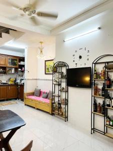 胡志明市Homestay Ms. Hoa的客厅配有沙发和墙上的电视