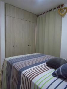 拉特瓦伊达hermoso apartamento amoblado的一间卧室配有带条纹毯子的床