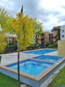 拉特瓦伊达hermoso apartamento amoblado的一座建筑前的游泳池,里面种着棕榈树