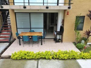 拉特瓦伊达hermoso apartamento amoblado的房屋前设有带木桌和椅子的庭院。
