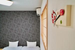 京都Haku Tofukuji的墙上的房间里设有两张床