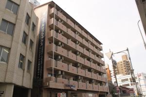 名古屋HOTEL LiVEMAX BUDGET Nagoya的一座高大的建筑,旁边是箱子