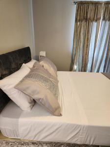 Thornton Heath4 Goodman Lodge & 7 goodman Lodge的一张带白色床单和枕头的床