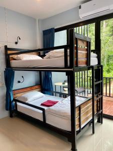 考索Boom Hostel Khao Sok的带窗户的客房内的两张双层床