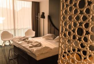 奥尔绍瓦Hotel Arka的一间卧室配有一张带两把椅子的床和一扇窗户