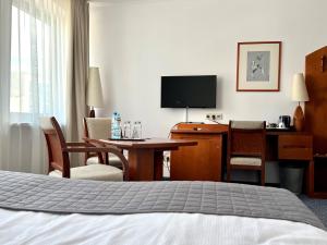 比得哥什城市酒店 的酒店客房设有一间带书桌和床的卧室