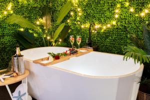 埃尔利海滩Bella Paradiso的配有酒杯和绿色墙壁的浴缸