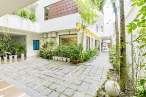 岘港Annie Danang Hotel & Apartment的一座种植了植物和篮球的建筑的庭院
