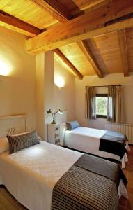 赫罗纳Mas Garriga Turisme Rural的卧室设有2张床和木制天花板。
