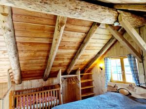 SeltenheimExperience this unique wooden house!的一间带木制天花板的卧室和一张位于客房内的床。