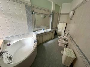 卡尔博尼亚Casa Serbariu, Sud Sardegna - Carbonia的一间带两个水槽、一个浴缸和两个卫生间的浴室