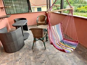 卡尔博尼亚Casa Serbariu, Sud Sardegna - Carbonia的庭院内的吊床,配有椅子和桌子